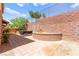 Beautiful backyard with a brick-paved patio, a decorative brick wall, and lush landscaping at 1252 Casa Palermo Cir, Henderson, NV 89011