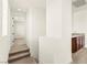 Clean, bright hallway featuring carpeted stairs, neutral colors, and a doorway leading to a living space at 1252 Casa Palermo Cir, Henderson, NV 89011