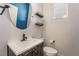 Well-lit powder room featuring a modern vanity, oval mirror, and open shelving at 133 Clouded Ave, Henderson, NV 89002