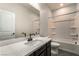 Well-lit bathroom featuring a marble countertop, dark wood cabinets, and a shower-tub combination at 133 Clouded Ave, Henderson, NV 89002