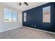 Cozy bedroom with a dark accent wall, two windows, and plush carpeting at 133 Clouded Ave, Henderson, NV 89002