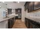 Kitchen with stainless steel appliances, marble backsplash, granite countertops, and wood flooring at 133 Clouded Ave, Henderson, NV 89002