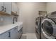 Laundry room featuring a farmhouse sink with stone countertops, modern appliances, and a stylish backsplash at 133 Clouded Ave, Henderson, NV 89002