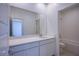 Modern bathroom featuring a vanity with a wide mirror, and a shower-tub combo with white tile at 145 Aqua Commons Ln, Henderson, NV 89015