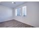 Bright bedroom featuring wood-look floors and natural light from two windows with modern blinds at 145 Aqua Commons Ln, Henderson, NV 89015