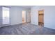 Spacious bedroom featuring plush gray carpeting, closet and bath access and balcony door at 145 Aqua Commons Ln, Henderson, NV 89015