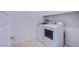 Well-lit laundry room with a side-by-side washer and dryer and overhead shelving at 145 Aqua Commons Ln, Henderson, NV 89015