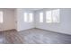 Sun-filled living room with wood-look flooring and multiple windows bringing in natural light at 145 Aqua Commons Ln, Henderson, NV 89015