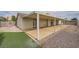 Large backyard featuring a covered patio, artificial turf, and rock landscaping at 1491 Sunrise View Dr, Las Vegas, NV 89110
