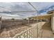 Backyard with covered patio, dirt area, brick wall, white fencing at 1491 Sunrise View Dr, Las Vegas, NV 89110