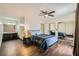 Comfortable bedroom featuring hardwood floors, ceiling fan, mirrored closet doors and ensuite sink area at 1491 Sunrise View Dr, Las Vegas, NV 89110