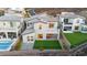 Aerial view of the property with a pool, covered patio, artificial turf, and a balcony at 2004 Peaceful Mesa Ct, Henderson, NV 89052