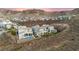 A luxurious home is showcased in an aerial view, highlighting a pool and outdoor space with desert landscaping and hillside backdrop at 2004 Peaceful Mesa Ct, Henderson, NV 89052