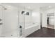 Bright bathroom features a glass shower and tub, with a view to a walk-in closet at 2004 Peaceful Mesa Ct, Henderson, NV 89052
