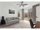 Comfortable bedroom with a gray sofa, neutral decor, and natural light from a sliding glass door at 2004 Peaceful Mesa Ct, Henderson, NV 89052