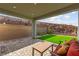 Covered patio with pavers, comfortable seating, lush artificial grass, and privacy wall at 2004 Peaceful Mesa Ct, Henderson, NV 89052