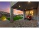 Backyard covered patio with pavers, comfortable seating, lush artificial grass, and hill views at 2004 Peaceful Mesa Ct, Henderson, NV 89052