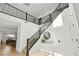 Elegant foyer featuring a staircase with black railings, wood floors, and a stylish round mirror at 2004 Peaceful Mesa Ct, Henderson, NV 89052