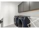 Laundry room equipped with front load washer and dryer, dark cabinets and white countertop at 2004 Peaceful Mesa Ct, Henderson, NV 89052