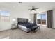 Bright main bedroom featuring a ceiling fan, gray furniture, and sliding doors with a view at 2004 Peaceful Mesa Ct, Henderson, NV 89052