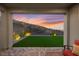 Covered patio with pavers and comfortable seating showcasing a tranquil backyard with a beautiful sunset at 2004 Peaceful Mesa Ct, Henderson, NV 89052