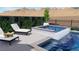 A luxurious pool and spa feature a tiled waterfall, poolside furniture, and lush landscaping at 2004 Peaceful Mesa Ct, Henderson, NV 89052