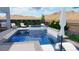 A luxurious pool and spa feature a tiled waterfall, poolside furniture, and desert landscaping at 2004 Peaceful Mesa Ct, Henderson, NV 89052