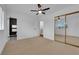 Spacious bedroom with modern ceiling fan, large window, and sleek mirrored closet doors at 2058 Citroen St, Las Vegas, NV 89142
