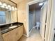 Well-lit bathroom featuring a granite countertop vanity, a large mirror, and a walk-in shower stall at 210 E Flamingo Rd # 215, Las Vegas, NV 89169