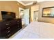 A cozy bedroom is shown, featuring a large dresser and television and entrances to the bathroom and kitchen at 210 E Flamingo Rd # 215, Las Vegas, NV 89169