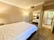 A bedroom featuring a bed with a white comforter, access to the laundry area, and a large mirror at 210 E Flamingo Rd # 215, Las Vegas, NV 89169