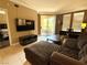 Relaxing living room with a large sectional sofa, TV, and sliding glass doors opening to a balcony at 210 E Flamingo Rd # 215, Las Vegas, NV 89169