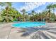 Expansive pool area with clear water, surrounded by lush greenery, palm trees, and lounge chairs for relaxation at 210 E Flamingo Rd # 215, Las Vegas, NV 89169