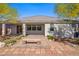 View of the charming back patio with stone pavers, landscaping, and covered area with bench seating at 2433 Cingoli St, Henderson, NV 89044