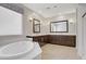 Well-lit bathroom showcasing soaking tub, double vanity, and dark wood cabinets at 2433 Cingoli St, Henderson, NV 89044