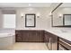 Spacious bathroom with a soaking tub, a double vanity and dark wood cabinets at 2433 Cingoli St, Henderson, NV 89044