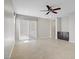 Open living room with tile floors, access to the patio, a ceiling fan, and built in dark wood cabinets at 2433 Cingoli St, Henderson, NV 89044