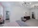Cozy bedroom featuring neutral tones, stylish lighting, and a glimpse into the en suite bathroom at 2489 Cingoli St, Henderson, NV 89044