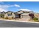 Charming single-story home boasts desert landscaping, a two-car garage and a neutral color palette at 2489 Cingoli St, Henderson, NV 89044