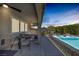 A covered outdoor living area features a dining table and a refreshing pool with lounge chairs, perfect for relaxation at 2489 Cingoli St, Henderson, NV 89044