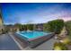 Inviting swimming pool with lounge chairs and stylish fire features, creating a relaxing outdoor oasis at 2489 Cingoli St, Henderson, NV 89044