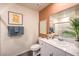 Modern bathroom features a toilet, vanity, sink and decorative artwork at 2534 Petunia Garden St # 222, North Las Vegas, NV 89081