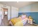 Cozy bedroom features a colorful bed, blue and cream colored walls, and closet with sliding doors at 2534 Petunia Garden St # 222, North Las Vegas, NV 89081
