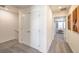 Bright hallway features modern neutral colors, carpet flooring and doors leading to the bedrooms at 2534 Petunia Garden St # 222, North Las Vegas, NV 89081