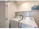 Clean laundry room features a washer, dryer, and storage shelf at 2534 Petunia Garden St # 222, North Las Vegas, NV 89081