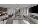 Expansive living area featuring modern fireplace, TV, comfortable seating, and seamless flow to the kitchen and staircase at 2631 Chance Canyon St, Henderson, NV 89044