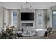 Modern living room with a cozy fireplace, large TV, stylish decor, and natural light streaming through expansive windows at 2631 Chance Canyon St, Henderson, NV 89044