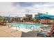 Community swimming pool with lounge chairs, umbrellas, and nearby neighborhood buildings at 2631 Chance Canyon St, Henderson, NV 89044