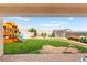 Expansive backyard featuring a large playset, a storage shed, and a well-maintained lawn at 2672 Painted Mist Ct, Las Vegas, NV 89142