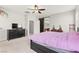 Comfortable bedroom with ceiling fan, television and glimpses into the attached bathroom at 2672 Painted Mist Ct, Las Vegas, NV 89142